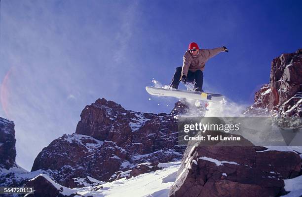 male snowboarder jumping off mountain, jebel toubkal, morocco - toubkal stock pictures, royalty-free photos & images