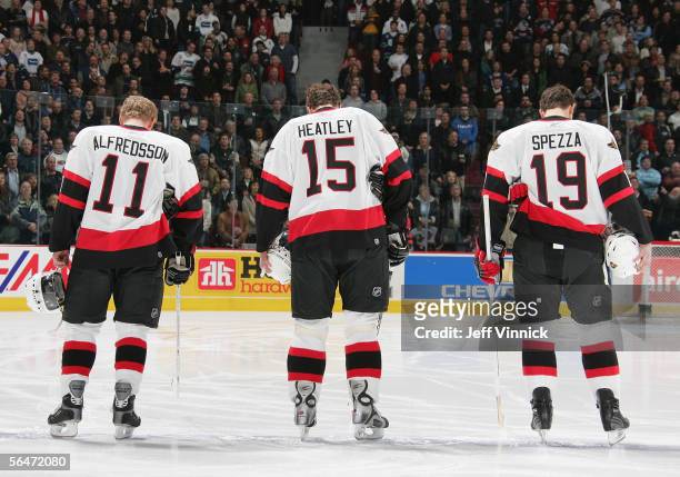 Daniel Alfredsson, Dany Heatley and Jason Spezza of the Ottawa Senators line up during the National Anthem before the NHL game against the Vancouver...