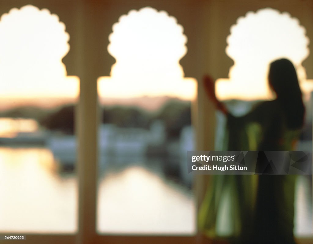 A woman looking at the Pichola Sea, India, Rajashtan