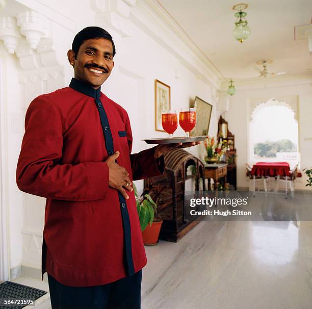 smiling waiter holding tray with drinks - hugh sitton india stockfoto's en -beelden