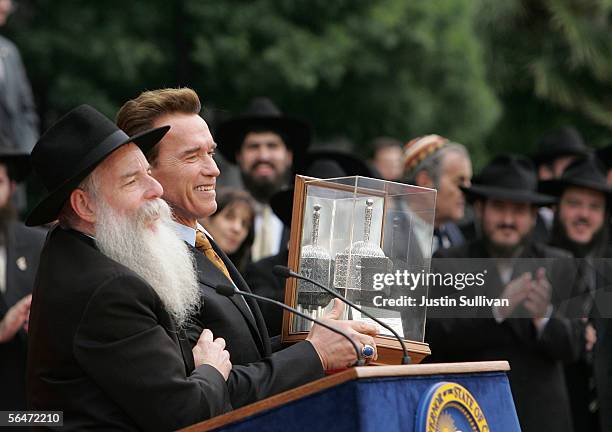 California Governor Arnold Schwarzenegger receives a silver dreidel from West Coast Chabad Director Rabbi Boruch Shlomo Cunin during the 12th annual...