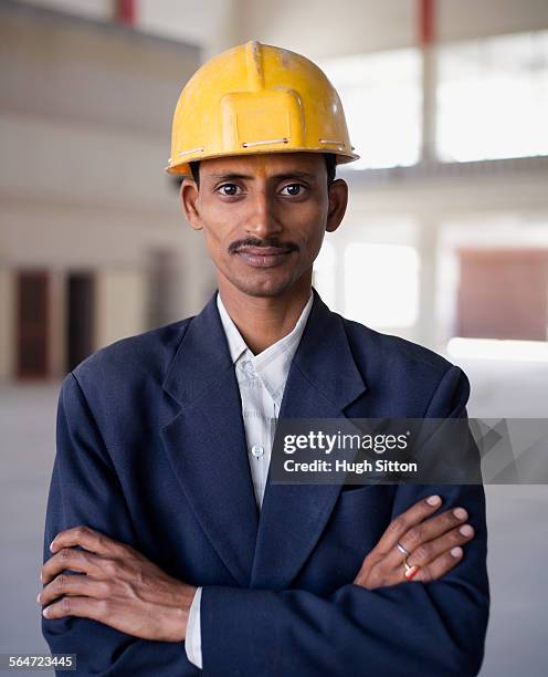businessman wearing hard hat - hugh sitton stock-fotos und bilder