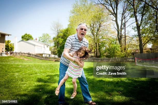 grandfather and granddaughter playing in garden - proud old man stock pictures, royalty-free photos & images