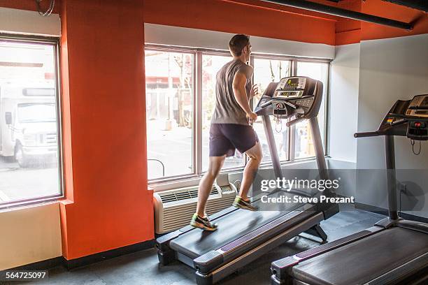 exhausted mid adult man running uphill on gym treadmill - colina acima imagens e fotografias de stock