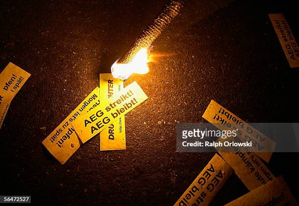 Man lights sheets of paper that read "AEG streikt ! AEG bleibt !" during a demonstration of AEG employees on December 20, 2005 in Nuremberg, Germany....