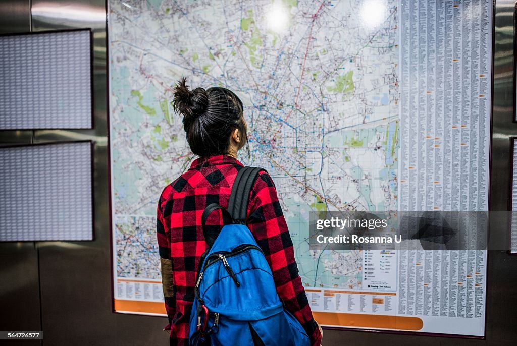Mid adult woman looking at street map, Milan, Italy