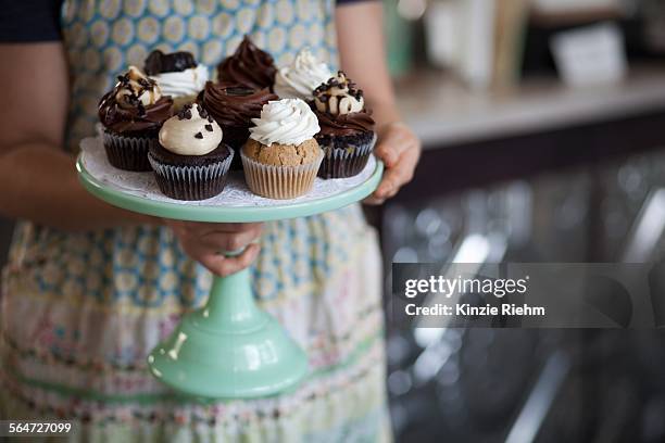 bakery owner carrying tray of allergy-friendly cupcakes - bandeja de bolo - fotografias e filmes do acervo