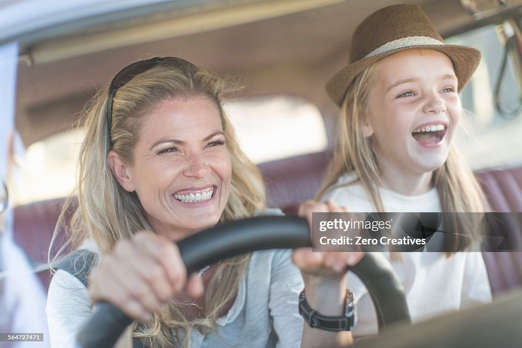 Mother and daughter in car together, smiling