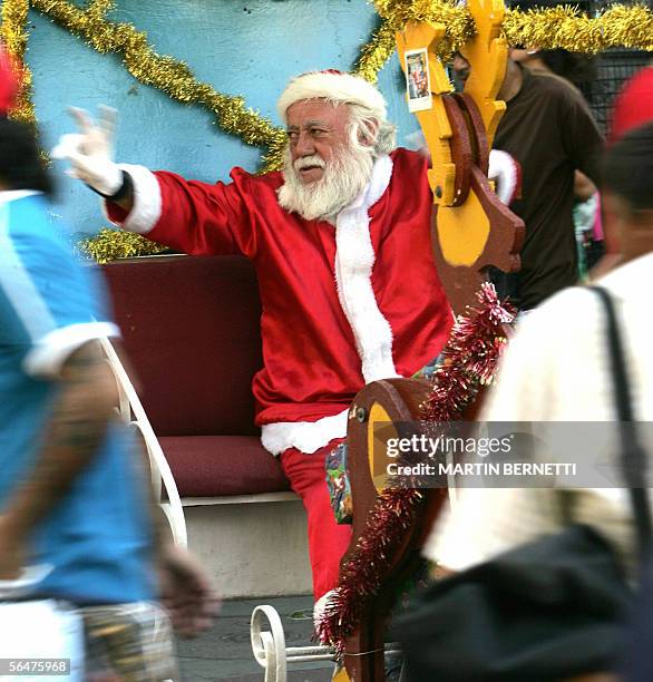 En chile los ninos pobres piden algo mas que un juguete al "Viejo Pascuero". Un anciano disfrazado de Papa Noel saluda a ninos en la Plaza de Armas...