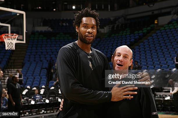 Michael Olowokandi of the Minnesota Timberwolves poses for a picture with David Miller, assistant coach of the New Orleans/Oklahoma City Hornets, on...