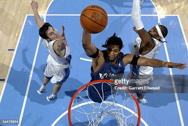 Etan Thomas of the Washington Wizards goes to the basket against Carmelo Anthony and Eduardo Najera of the Denver Nuggets on December 21, 2005 at the...