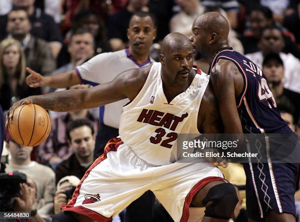 Center Shaquille O'Neal of the Miami Heat pushes center Marc Jackson of the New Jersey Nets on December 23, 2005 at the American Airlines Arena in...