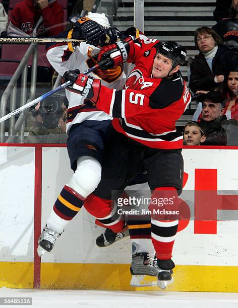 Colin White of the New Jersey Devils checks Bobby Holik of the Atlanta Thrashers during their game on December 23, 2005 at Continental Airlines Arena...