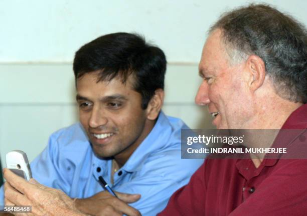 India cricket coach Greg Chappell shows team captain Rahul Dravid pictures on his mobile phone during a Board of Control for Cricket in India meeting...