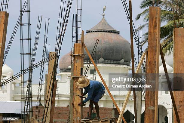 An Acehnese works on the construction of a house December 24, 2005 in Banda Aceh, Aceh, Indonesia. Indonesia's Rehabilitation and Reconstruction...