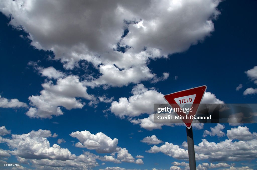 Yield sign with clouds