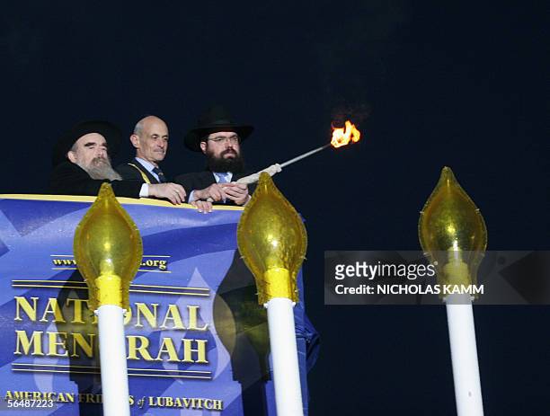 Homeland Security Secretary Michael Chertoff helps rabbis Levi Shemtov and Abraham Shemtov of the American Friends of Lubavitch light the first...