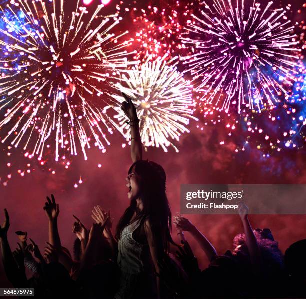 woman amongst crowd enjoying firework display - firework display stock-fotos und bilder