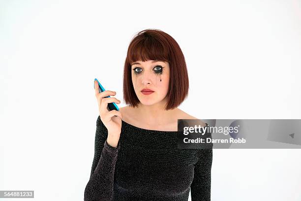 beautiful young woman holding telephone, crying - ミディアムヘア ストックフォトと画像