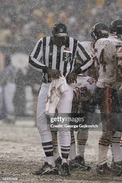 Umpire Chad Brown tries to keep the ball dry as snow falls during a game between the Pittsburgh Steelers and Chicago Bears at Heinz Field on December...