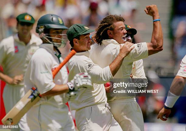 Australian bowler Andrew Symonds is congratulated by captain Ricky Ponting after dismissing South African batsman Mark Boucher on the third day of...