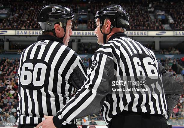 Linesmen Pat Dapuzzo and Darren Gibbs share a few words during a break in the NHL game between the Los Angeles Kings and the Vancouver Canucks at...