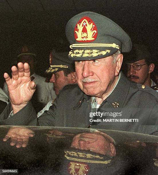 Chilean General Agusto Pinochet waves as he arrives at a military base in Salinas, Ecuador 27 November 1997. The Chilean Justice opened a criminal...