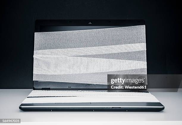 laptop with gauze bandage - mullbinde stock-fotos und bilder