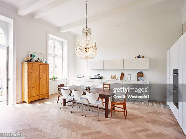 modern kitchen with dining table in a refurbished old building - chandelier stock pictures, royalty-free photos & images