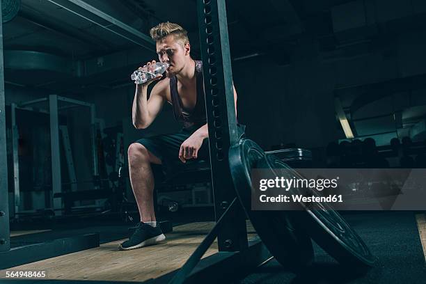 young man drinking water in gym - bodybuilding furious stock-fotos und bilder