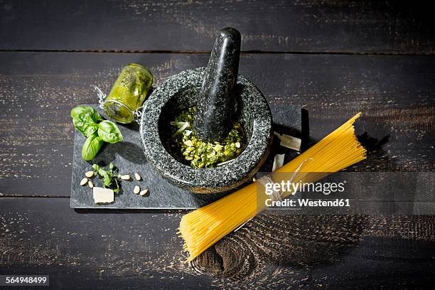 preparing pesto alla genovese with mortar, uncooked spaghetti - pistou photos et images de collection