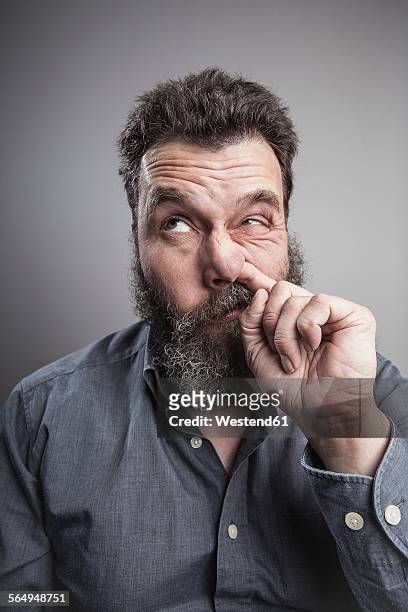 portait of a mature man with full beard, picking his nose - picarse la nariz fotografías e imágenes de stock