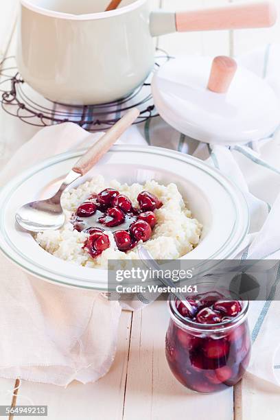 rice pudding with cherry sauce - reispudding stock-fotos und bilder