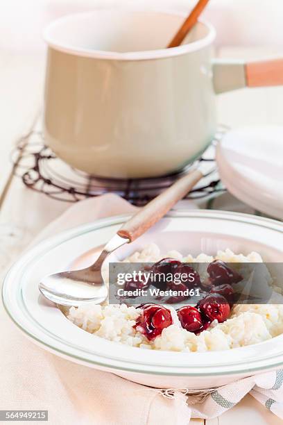 rice pudding with cherry sauce - milchreis stock-fotos und bilder
