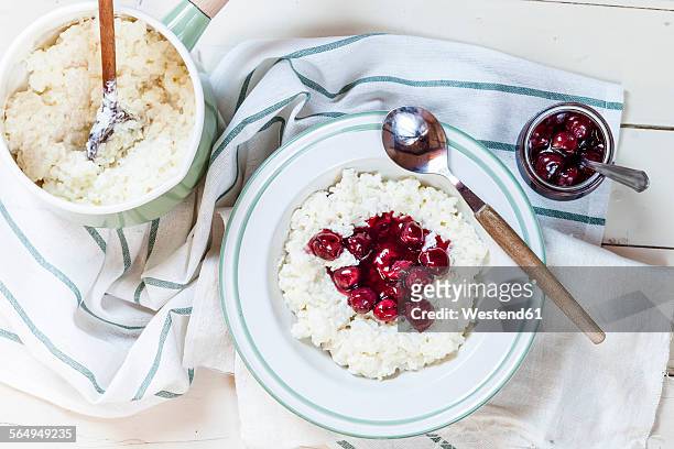 rice pudding with cherry sauce - milchreis stock-fotos und bilder