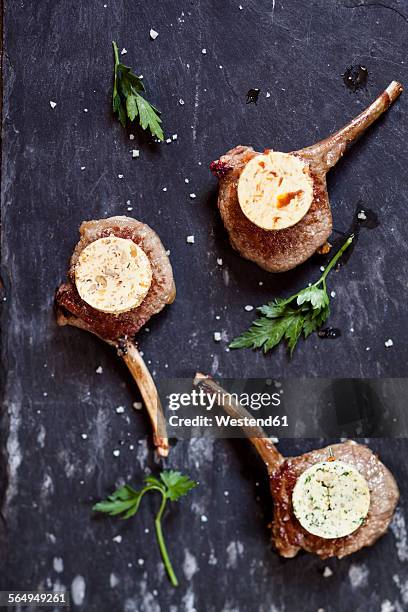 three differently flavoured compound butters on lamb chops and parsley leaves on slate - nut butter stock pictures, royalty-free photos & images