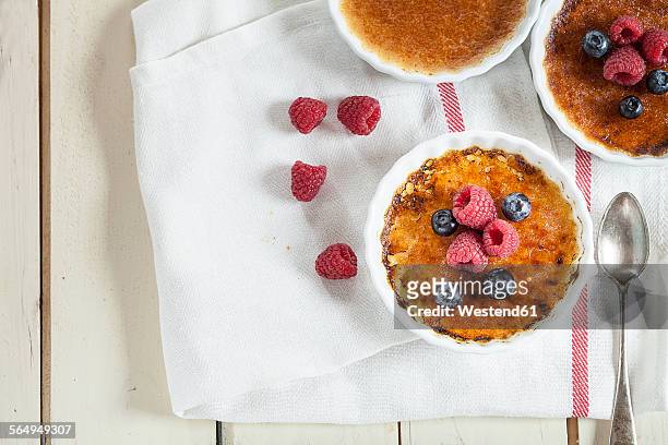 creme brulee with berries and spoon - creme brulee stock pictures, royalty-free photos & images