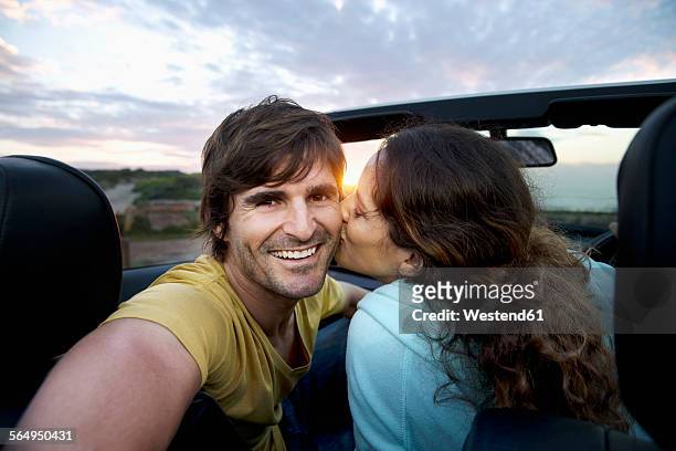 south africa, happy couple in convertible at the coast at sunrise - toyota south africa motors stock pictures, royalty-free photos & images