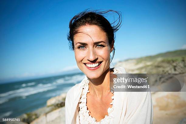 south africa, portrait of smiling woman with blowing hair - beautiful mature woman stock pictures, royalty-free photos & images