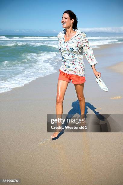 south africa, laughing woman walking along the beach - pantalón corto fotografías e imágenes de stock