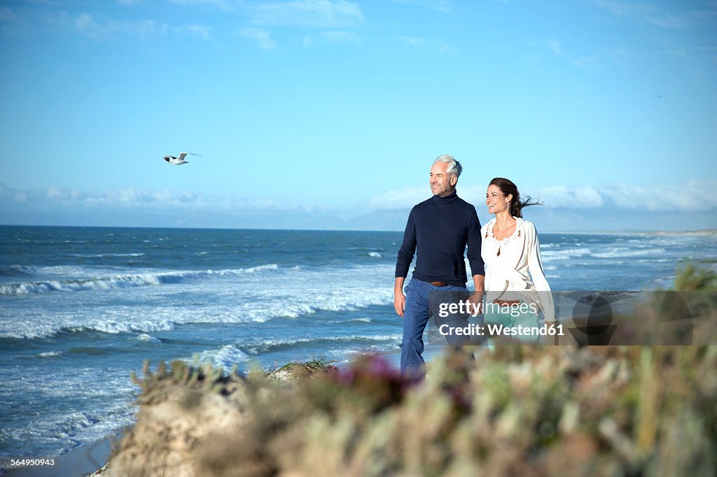 South Africa, couple walking along the coast hand in hand