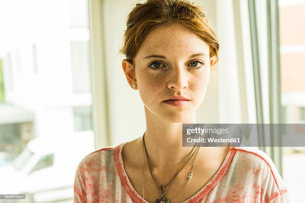 Portrait of redheaded young woman with freckles