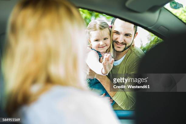 girl with father saying goodbye to leaving mother in car - separation foto e immagini stock