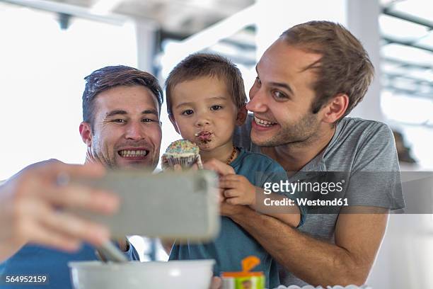 Gay couple baking cake with son