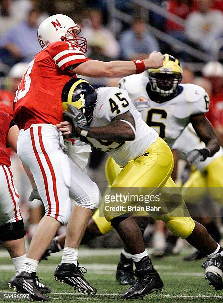 Quarterback Zac Taylor of the Nebraska Cornhuskers throws an interception as he gets hit by Dave Harris of the Michigan Wolverines during the first...