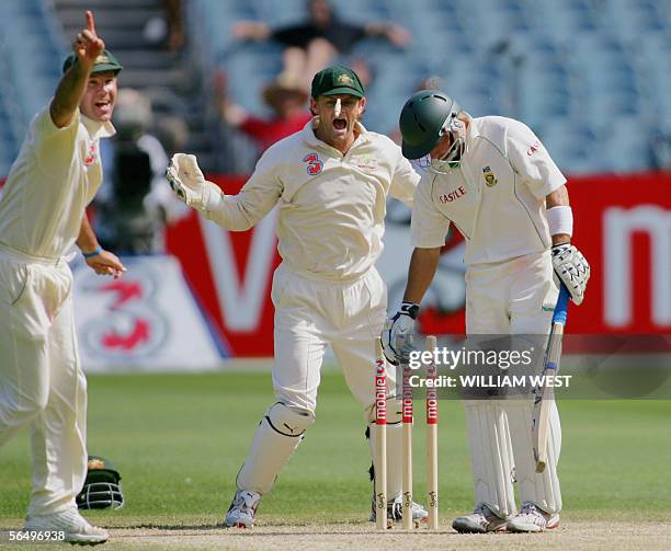 Australian fieldsmen Ricky Ponting and Adam Gilchrist celebrate spinner Shane Warne bowling South Africa batsman Herschelle Gibbs on the fourth day...