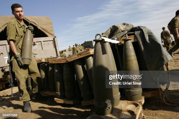 Israeli army soldiers prepare ammunition for their 155mm mobile artillery cannon after a night of action against Palestinian militants in the...