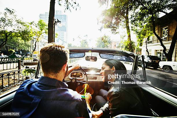 Woman smiling at boyfriend driving convertible