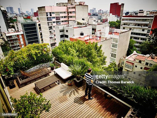 Man with digital tablet on rooftop terrace of home