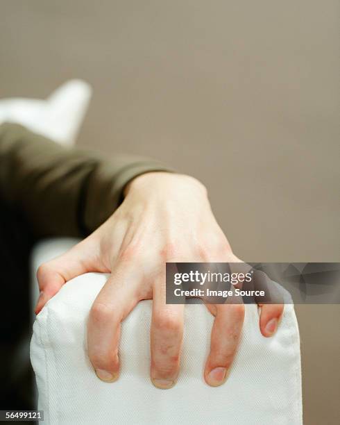 a male hand grabbing the sofa arm - greif stock-fotos und bilder